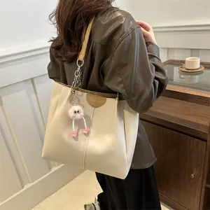 Modern cream PU leather tote bag with contrast yellow straps and pink plush charm