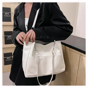 White faux leather tote bag detail with metal ring chain and side pocket accents