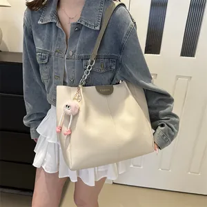 Creamy white oversized tote bag with metal chain strap and pink plush charm accessory