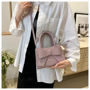 Close-up of woven texture and large bow detail on this elegant lavender crossbody handbag