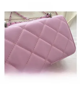 Gros plan détaillé du sac bandoulière rose matelassé avec coutures et bandoulière chaîne