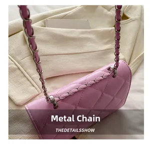 Détail de l'œillet métallique et de la bandoulière en cuir rose matelassé d'un sac