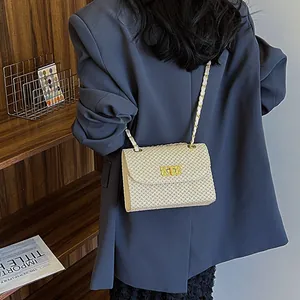 Fashionable beige woven straw shoulder bag with gold metal clasp and chain strap for summer