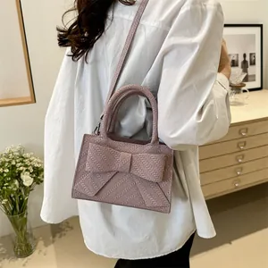 Chic mauve crossbody bag with large bow and woven texture for summer daily outfits