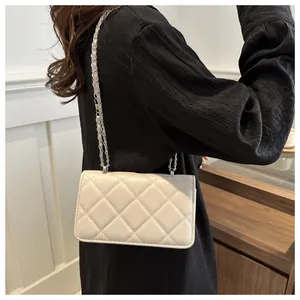 Sac à bandoulière matelassé blanc avec chaîne argentée porté par un mannequin