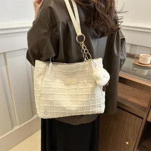 Borsa tote in tweed bianco con catena dorata e ciondolo a forma di pecora su modella