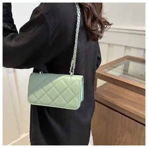 Sac bandoulière matelassé vert menthe avec chaîne porté par un mannequin de profil