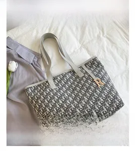 Vue détaillée du sac cabas en toile jacquard avec motif logo et pendentif doré