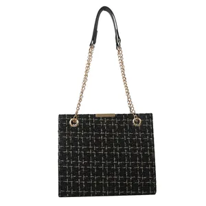 Elegant black tweed tote bag with gold chain strap and classic woven texture