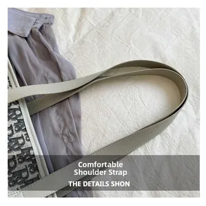 Détail de la bandoulière en cuir synthétique sur un sac cabas en toile jacquard