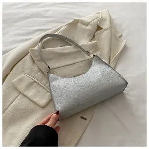 Dettaglio della borsa hobo argento glitterata con paillettes e anelli in metallo oro