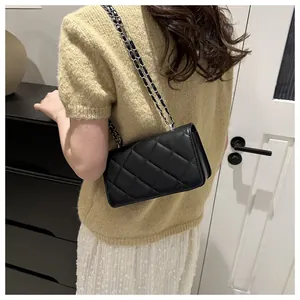 Détail du sac à bandoulière noir matelassé avec une élégante bandoulière en chaîne