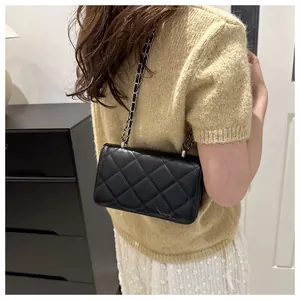 Détail du sac à bandoulière en cuir matelassé noir avec bandoulière chaîne et rabat