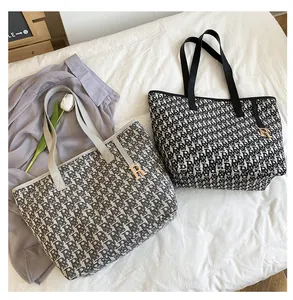 Détail des sacs cabas en toile avec motif monogramme RB et pendentif en lettre R dorée