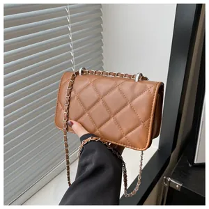 Détail du sac bandoulière marron matelassé avec chaîne argentée et texture cuir