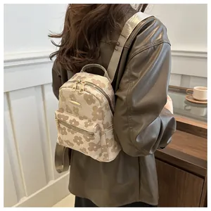 Detail of floral mini backpack showing litchi texture and double zipper on shoulder