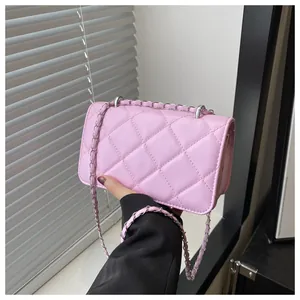 Détail du sac à bandoulière matelassé rose avec chaîne en argent et texture PU