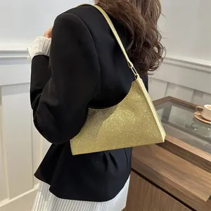 Elegante borsa sottobraccio con paillettes dorate da donna abbinata a un outfit moderno
