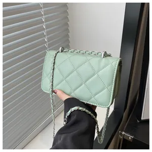 Détail de la texture matelassée vert menthe du sac bandoulière avec chaîne argentée