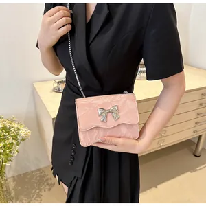 Détail d'un petit sac rose avec boucle en nœud argenté et texture cuir plissé