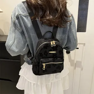 Minimalist black floral embroidered backpack for women with gold hardware detail