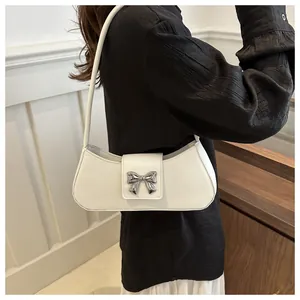 Dettaglio della borsa hobo in pelle bianca con fibbia a fiocco in argento sulla spalla