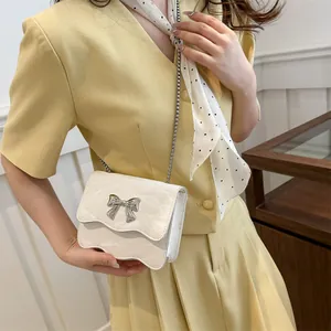 Mini sac bandoulière crème chic avec nœud en métal et texture à volants