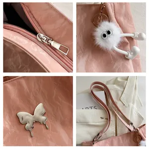 Detail van de roze fluwelen tote met zilveren vlinder en zachte pluche bal sleutelhanger