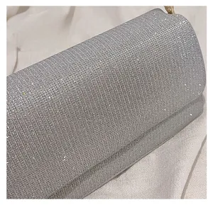 Close-up of a silver PU evening clutch with colorful rhinestones and gold chain strap