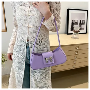 Dettaglio della borsa a mezzaluna viola con grande fibbia a fiocco in metallo argento