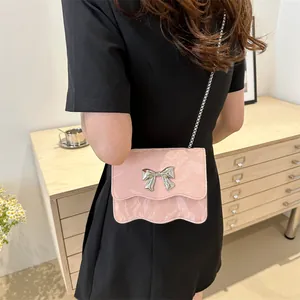 Mini sac bandoulière rose motif marbre avec nœud argenté et bordure ondulée sur modèle
