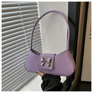 Dettaglio della mini borsa lilla con fiocco in metallo argento e chiusura magnetica elegante