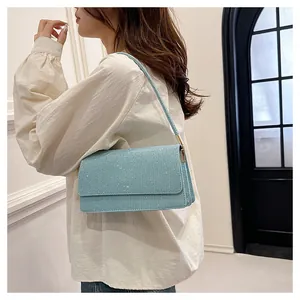 Light blue glitter PU shoulder bag with rectangular flap shown on person in a room