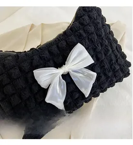 Detailed macro view of black bubble cotton fabric with white organza bow and metal zipper