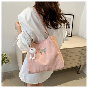 Detail van roze tote bag met zilveren vlindergesp en een zachte pluche hanger