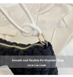 Detail of puffy cloud bag showing black bubble texture and white PU woven shoulder strap