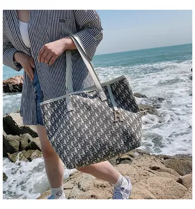 Gros plan du grand cabas en toile avec motif jacquard et détail de charm en métal en R