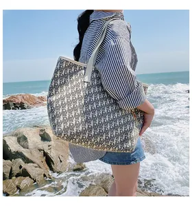 Détail du sac cabas en jacquard bleu et beige avec anses en cuir sur des rochers