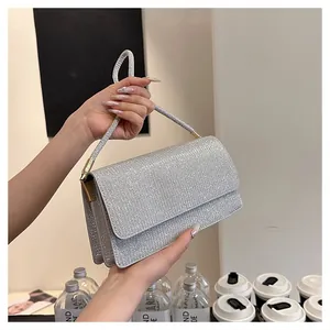 Close-up of sparkling silver glitter evening handbag with rectangular flap and single handle