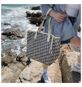 Détail du sac cabas en jacquard monogramme avec bordure cuir et pendentif R