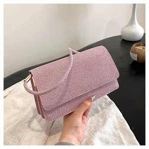 Macro detail of a pale pink glitter clutch bag showing shimmering texture and handle