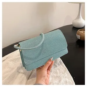 Detail shot of mint green handbag with shimmering rhinestones and cylindrical handle