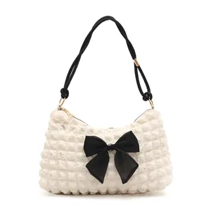 Chic off-white puff cloud shoulder bag with textured fabric and a large black bow detail