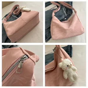Macro detail of pink wrinkled faux leather bag with silver zipper and plush bear charm
