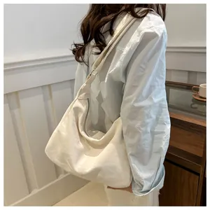 Detailed side view of a large cream tote bag showing soft texture and metal zipper closure