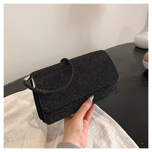 Detailed close-up of a black sequin evening clutch bag with a round ring handle