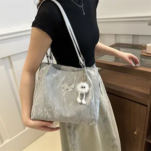 Grote grijze tote bag met vlinderlogo en pluizige monster hanger voor dagelijks gebruik