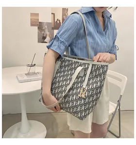 Vue détaillée du grand sac cabas en toile avec motif monogramme et anse en cuir