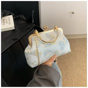 Detail of vintage blue satin shell bag with gold butterfly embroidery and clasp