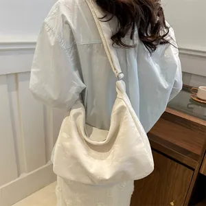 Minimalist white hobo shoulder bag with adjustable strap in textured leather for women